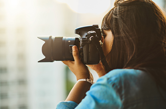 Camera voor beginners - Vrouw maakt foto's met haar nieuwe camera.