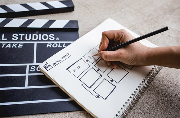 Tips on how to film – an amateur filmmaker designing a story board for a film.