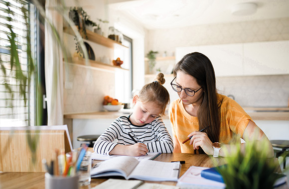 Jak motywować dziecko do nauki w szkole – mama pomaga córce w zadaniu domowym. Jak motywować dziecko do nauki w szkole – mama pomaga córce w zadaniu domowym.