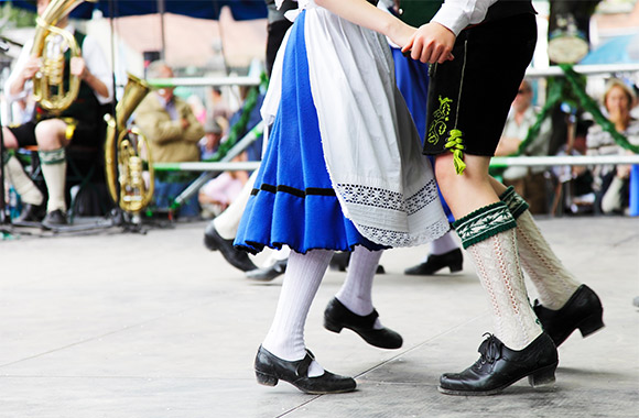 Taniec ludowy z różnych zakątków świata: para w bawarskich strojach ludowych tańczy na Oktoberfest.