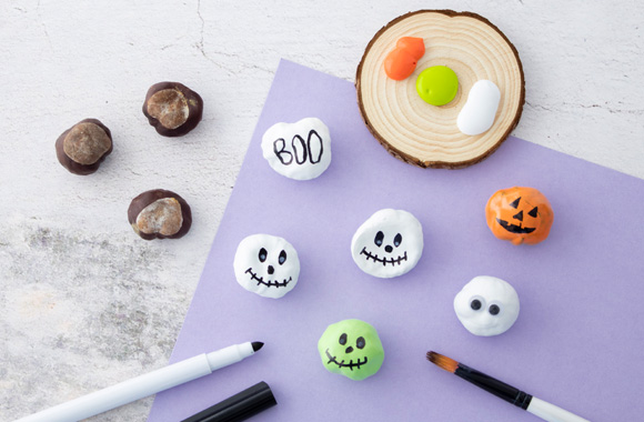 Making Halloween decorations with children: small pumpkins and ghosts made out of conkers. 