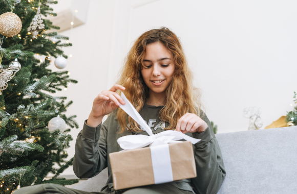 Christmas presents for teenagers – a teenage girl unwrapping her Christmas present. Christmas presents for teenagers – a teenage girl unwrapping her Christmas present.