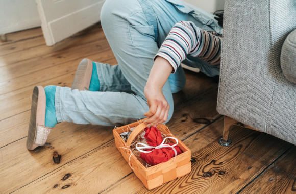 Easter gifts for children: a child looking under the sofa for an Easter gift. Easter gifts for children: a child looking under the sofa for an Easter gift.