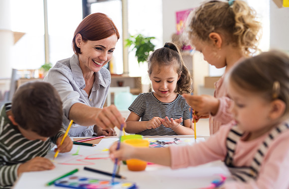 Kindergartenkinder malen zusammen am Tisch. Kindergartenkinder malen zusammen am Tisch.