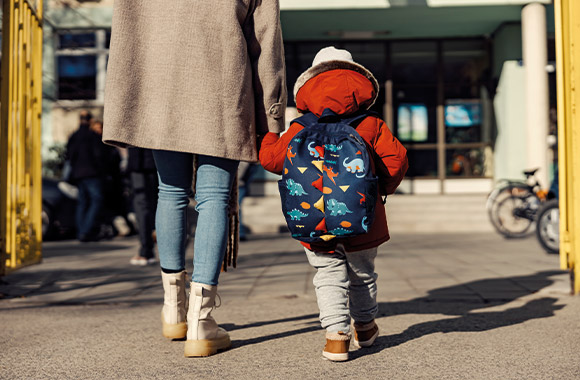 Kindergartentasche – Mutter bringt ihr Kind in den Kindergarten. Kindergartentasche – Mutter bringt ihr Kind in den Kindergarten.