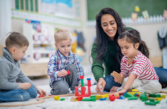 Kinderopvang gewenning: moeder speelt met haar kind in de kleuterschool. Kinderopvang gewenning: moeder speelt met haar kind in de kleuterschool.