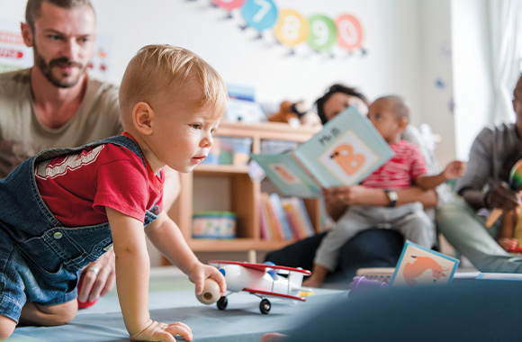 Kennismakingsmodel: zoon speelt in het kinderdagverblijf en zijn vader kijkt toe. Kennismakingsmodel: zoon speelt in het kinderdagverblijf en zijn vader kijkt toe.