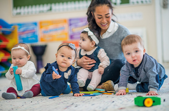 Crèche - peuters spelen samen met de opvoeder.