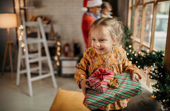 Christmas presents for children – a little girl is excited to open her Christmas presents. Christmas presents for children – a little girl is excited to open her Christmas presents.