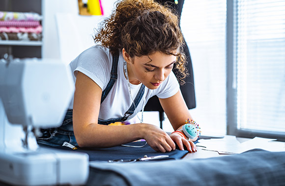 A textile and fashion tailor working with patterns on a garment. A textile and fashion tailor working with patterns on a garment.