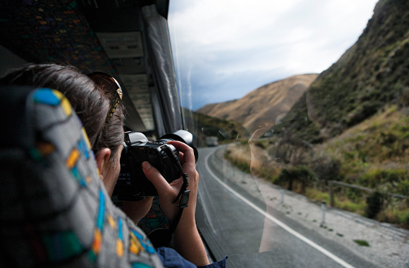 Eco-travel: a woman travelling by coach taking pictures of the passing scenery. Eco-travel: a woman travelling by coach taking pictures of the passing scenery.