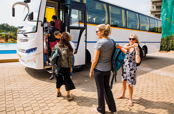 Reizen en milieubescherming: vakantiegangers stappen in een toerbus. Reizen en milieubescherming: vakantiegangers stappen in een toerbus.