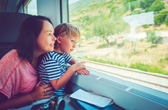 Sustainable modes of transport with children: a mother and son travelling by train.