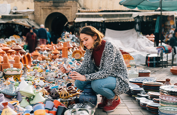 Soft tourism: a woman buying souvenirs at a market in Morocco.