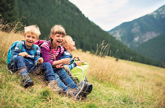 Eco-friendly family holidays: siblings taking a break from hiking.