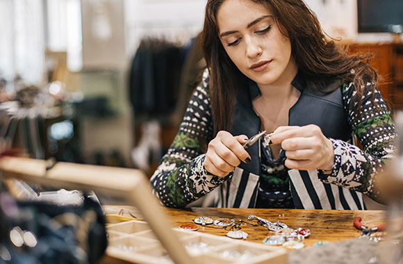 A young woman working on the production of silver jewellery. A young woman working on the production of silver jewellery.