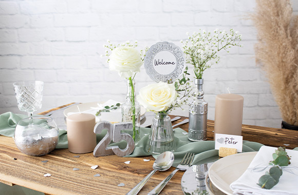 Uitnodigingskaarten zilveren huwelijk: zelfgemaakte uitnodigingen liggen op een tafel.