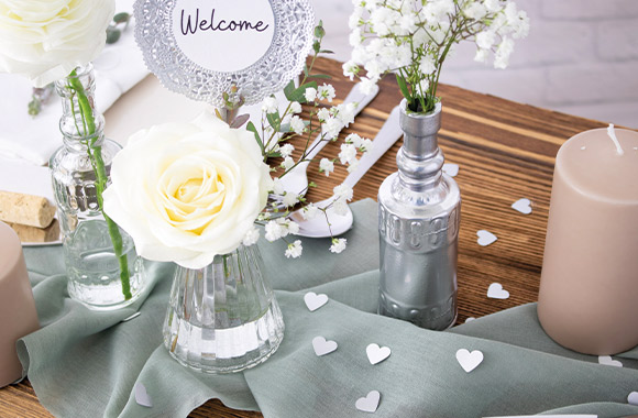 Silver wedding anniversary decoration: glass and silver vases with white roses. Silver wedding anniversary decoration: glass and silver vases with white roses.