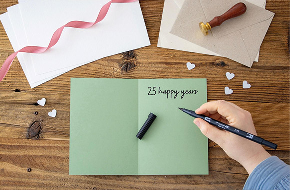 DIY Silver wedding invitations: a person writing an invitation.