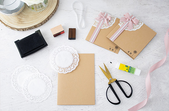 Craft materials for a homemade silver wedding invitation with lace.