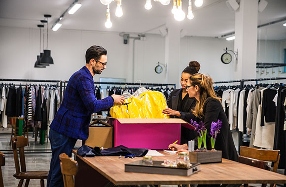 Fashion management professions: store managers and sales assistants having a look at new merchandise. Fashion management professions: store managers and sales assistants having a look at new merchandise.