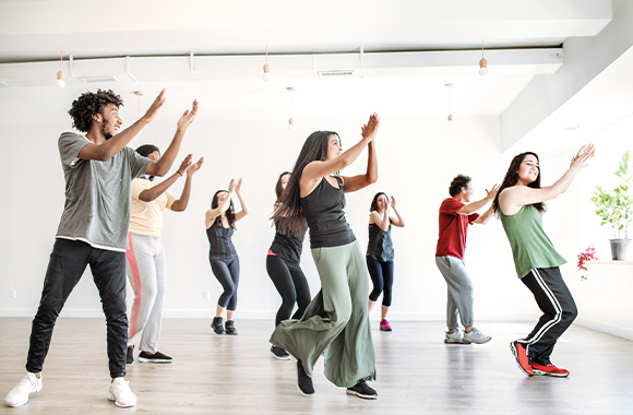 Tanzsport: Tanzgruppe tanzt Zumba in Sportraum.