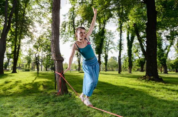 Gift for 12-year-olds: a young girl on a slackline in the park. Gift for 12-year-olds: a young girl on a slackline in the park.