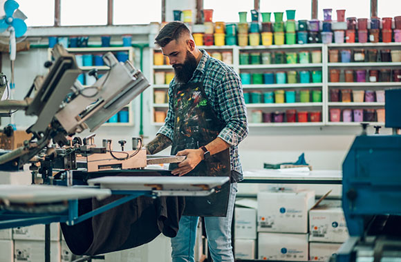 Job roles in the field of textile technology: a print designer in a factory preparing the machine for printing. Job roles in the field of textile technology: a print designer in a factory preparing the machine for printing.