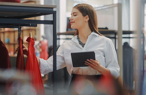 Visual merchandiser training: a young woman in a shop checking the product presentation. Visual merchandiser training: a young woman in a shop checking the product presentation.