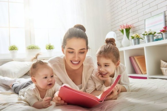 Mutter liest ihren Kindern eine Gute-Nacht-Geschichte vor