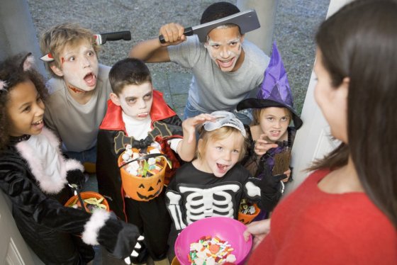 Kinder in Kostümen an Halloween spielen Süßes oder Saures Kinder in Kostümen an Halloween spielen Süßes oder Saures