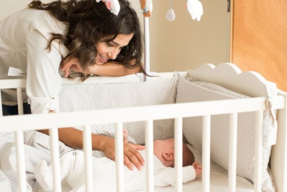 Mutter bringt ihr Baby ins Bettchen Mutter bringt ihr Baby ins Bettchen