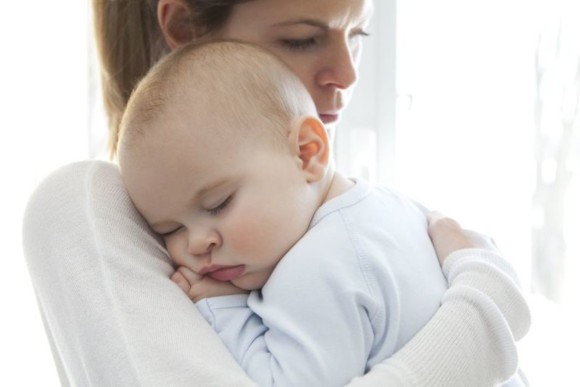 Mutter läuft mit dem Baby auf dem Arm durch die Wohnung, damit es einschläft Mutter läuft mit dem Baby auf dem Arm durch die Wohnung, damit es einschläft