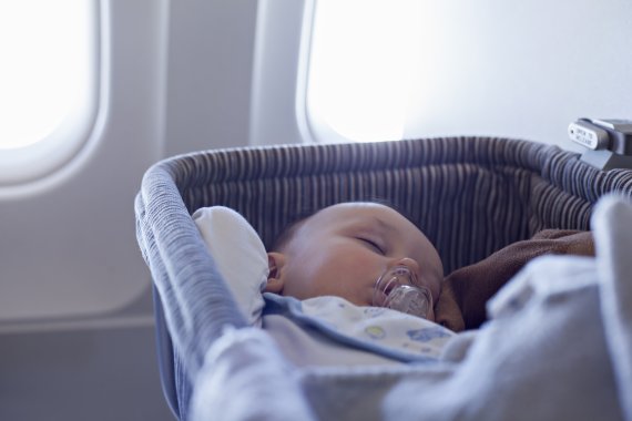 Baby schläft im Flugzeug-Bassinet Baby schläft im Flugzeug-Bassinet