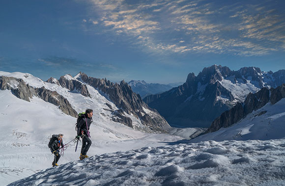 Alpinismo de alta montaña: dos alpinistas pasan por una zona de nieve y hielo. Alpinismo de alta montaña: dos alpinistas pasan por una zona de nieve y hielo.