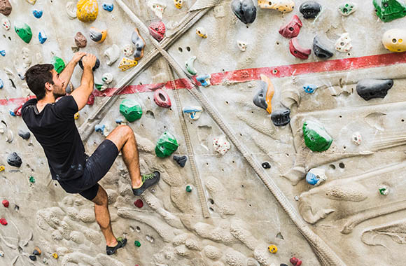 Boulderen – Jonge man lost een probleem op tijdens het boulderen. Boulderen – Jonge man lost een probleem op tijdens het boulderen.
