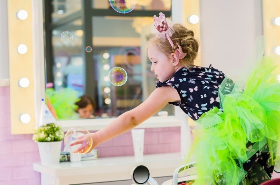 Dziewczynka podczas czesania łapie bańki mydlane
