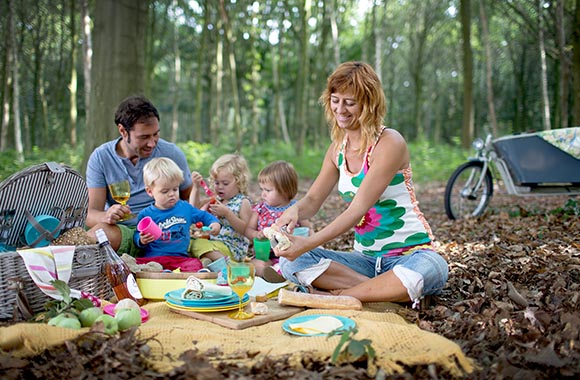 Familie picknickt tijdens de fietsroute in het Bulskampveld Familie picknickt tijdens de fietsroute in het Bulskampveld