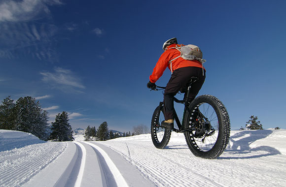un homme fait du Fat Bike en hiver à la montagne un homme fait du Fat Bike en hiver à la montagne