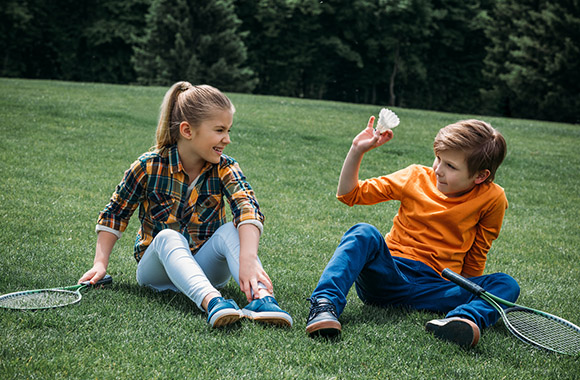 Kinder auf Wiese nach dem Badmintontraining Kinder auf Wiese nach dem Badmintontraining