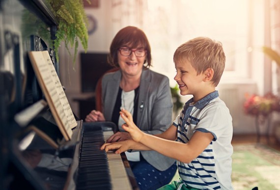 Un enfant apprend le piano avec un professeur