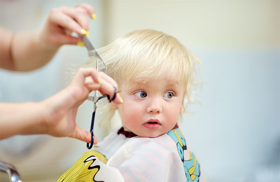 Kleinem Kind werden die Haare geschnitten