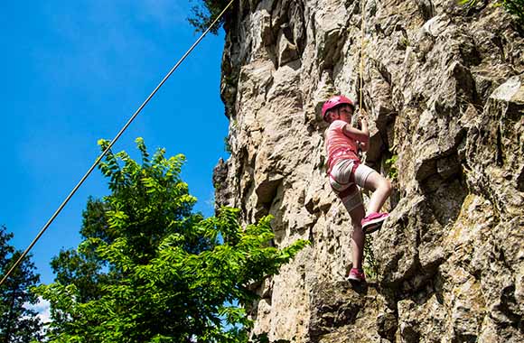 Skałka wspinaczkowa dla dzieci – dziewczynka wspinająca się na skałę