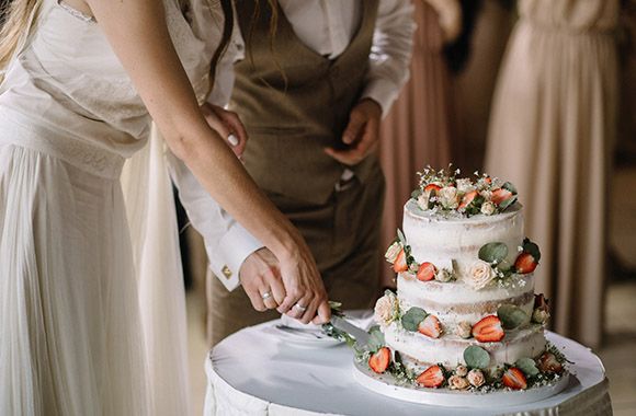 Świeżo upieczeni małżonkowie kroją tort weselny Świeżo upieczeni małżonkowie kroją tort weselny