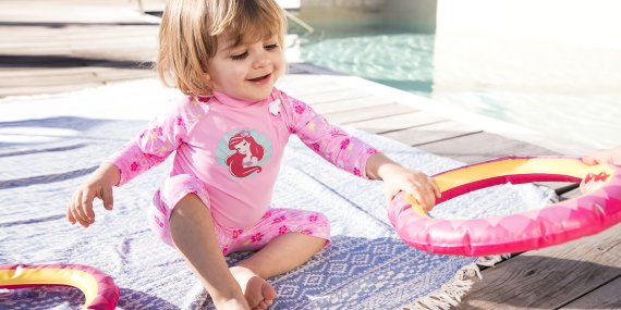 Una niña pequeña vestida con ropa adecuada para protegerse del sol