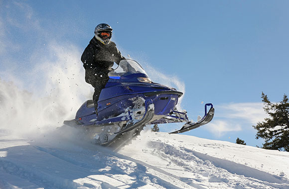 Un aficionado recorriendo una ruta de motos de nieve Un aficionado recorriendo una ruta de motos de nieve