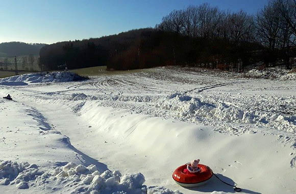 Snowtubing - dziecko zjeżdża po specjalnym torze do snowtubing’u Snowtubing - dziecko zjeżdża po specjalnym torze do snowtubing’u