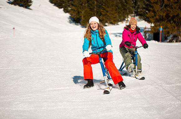 deux femmes font du Snow Bike sur une piste de ski deux femmes font du Snow Bike sur une piste de ski