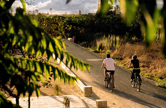 Un par de ciclistas realizando la ruta de la vía verde entre Dénia y Els Poblets Un par de ciclistas realizando la ruta de la vía verde entre Dénia y Els Poblets