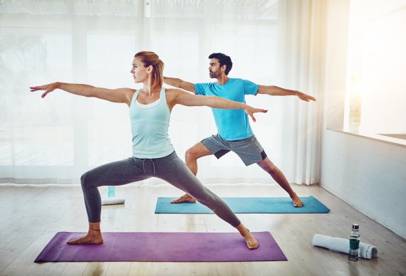 Yoga stärkt Geist und Körper ein Paar beim Yoga